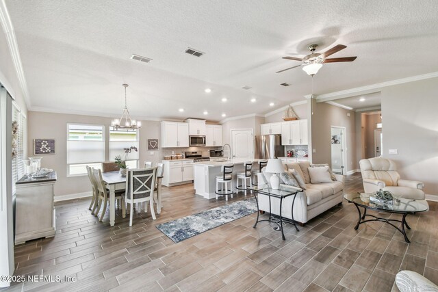 100 Dove Tree Ln, Saint Augustine, FL 32095 - living area featuring ceiling fan, ornamental molding, recessed lighting, light wood finished floors, and a chandelier