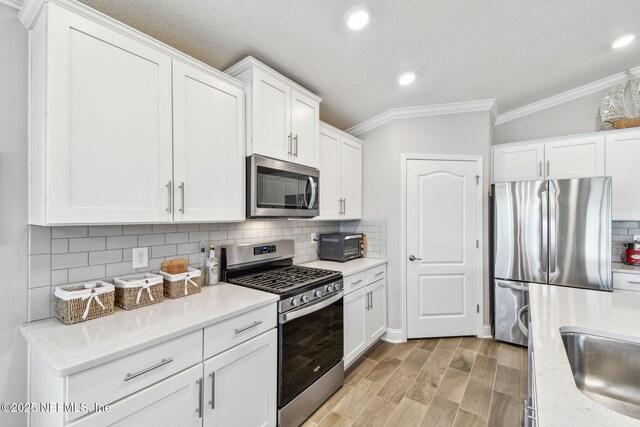 100 Dove Tree Ln, Saint Augustine, FL 32095 - kitchen featuring stainless steel appliances, crown molding, white cabinets, tasteful backsplash, and recessed lighting