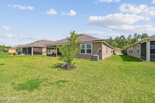 100 Dove Tree Ln, Saint Augustine, FL 32095 - back of property featuring a sunroom, a lawn, stucco siding, and roof with shingles
