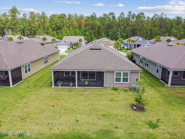 100 Dove Tree Ln, Saint Augustine, FL 32095 - back of property featuring a sunroom, a shingled roof, a lawn, and a residential view
