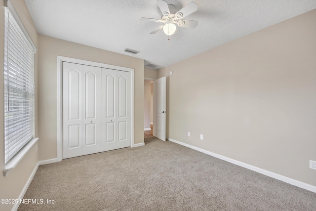 168 Pinehurst Pointe Dr, Saint Augustine, FL 32092 - unfurnished bedroom with carpet floors, a closet, a textured ceiling, and multiple windows