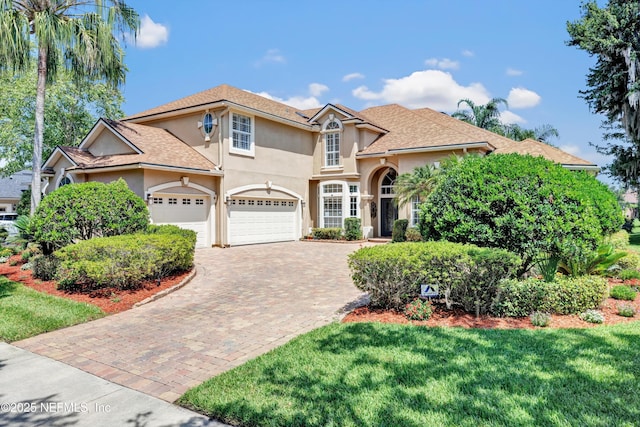 168 Pinehurst Pointe Dr, Saint Augustine, FL 32092 - traditional-style house featuring stucco siding, decorative driveway, a front lawn, and a garage