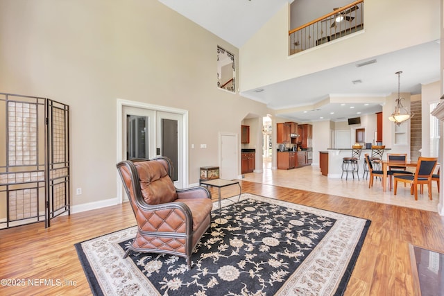 168 Pinehurst Pointe Dr, Saint Augustine, FL 32092 - living room featuring a towering ceiling, arched walkways, and light wood-type flooring
