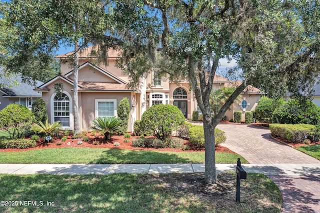 168 Pinehurst Pointe Dr, Saint Augustine, FL 32092 - view of property hidden behind natural elements featuring stucco siding, decorative driveway, and a front yard