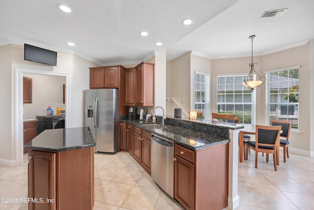 168 Pinehurst Pointe Dr, Saint Augustine, FL 32092 - kitchen featuring appliances with stainless steel finishes, washer and dryer, dark stone counters, crown molding, and recessed lighting