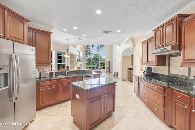 168 Pinehurst Pointe Dr, Saint Augustine, FL 32092 - kitchen featuring stainless steel appliances, under cabinet range hood, tasteful backsplash, arched walkways, and a textured ceiling
