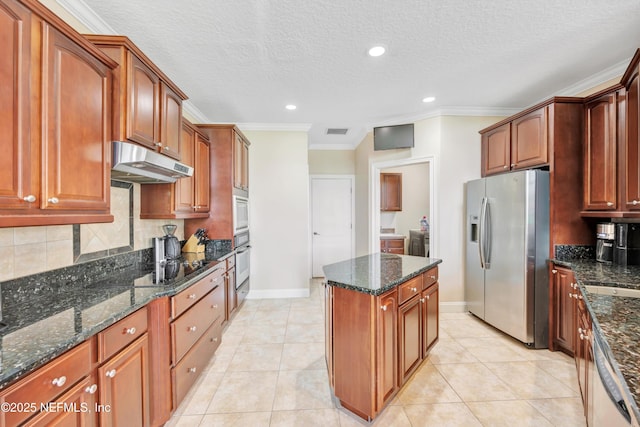 168 Pinehurst Pointe Dr, Saint Augustine, FL 32092 - kitchen with stainless steel appliances, under cabinet range hood, a kitchen island, ornamental molding, and decorative backsplash