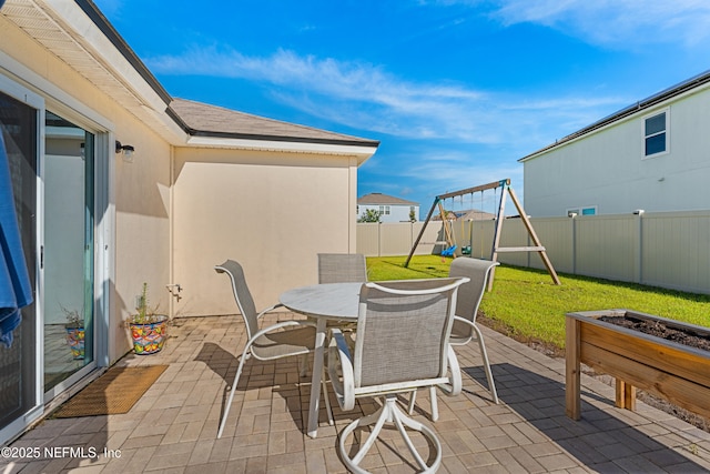 197 Jarama Cir, Saint Augustine, FL 32084 - fenced backyard with a patio area, a playground, outdoor dining area, and an outdoor fire pit