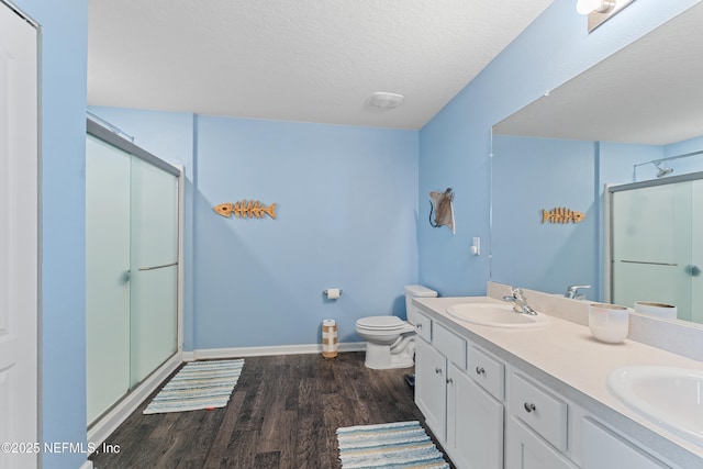 197 Jarama Cir, Saint Augustine, FL 32084 - bathroom featuring a stall shower, wood finished floors, double vanity, and a textured ceiling