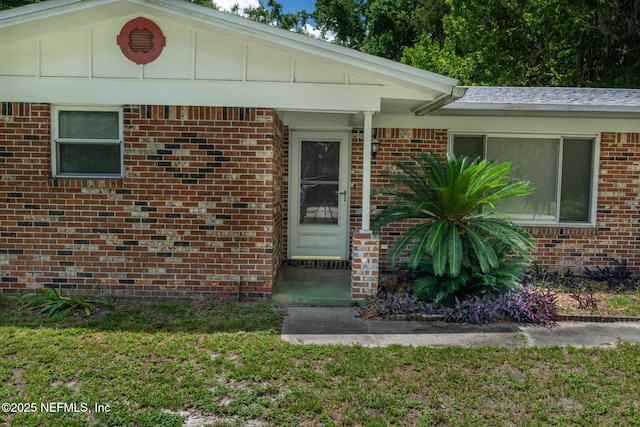 136 Hollywood Forest Dr, Fleming Island, FL 32003 - doorway to property with a yard and brick siding