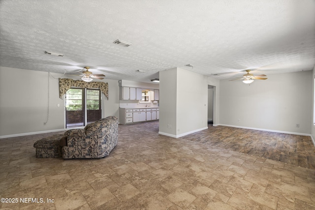 136 Hollywood Forest Dr, Fleming Island, FL 32003 - unfurnished living room with ceiling fan, stone finish flooring, and a textured ceiling