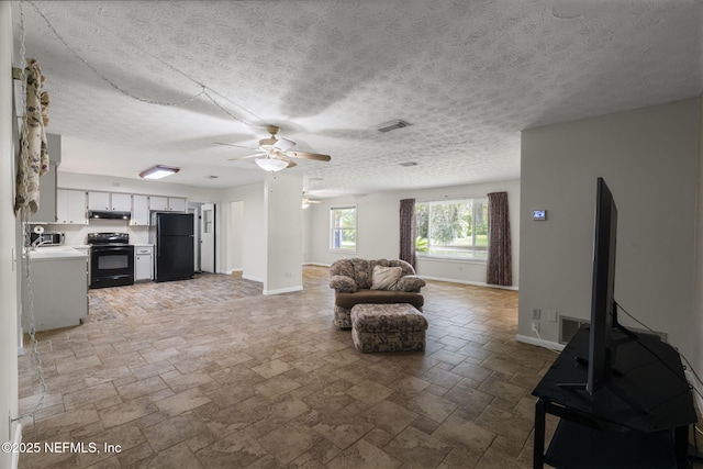 136 Hollywood Forest Dr, Fleming Island, FL 32003 - living room featuring a ceiling fan, stone tile floors, and a textured ceiling