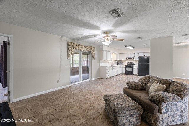 136 Hollywood Forest Dr, Fleming Island, FL 32003 - living area featuring a ceiling fan, light stone finish floors, and a textured ceiling