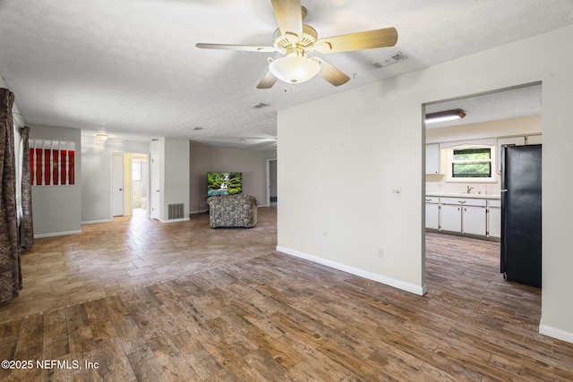 136 Hollywood Forest Dr, Fleming Island, FL 32003 - unfurnished living room with a ceiling fan, a textured ceiling, and wood finished floors