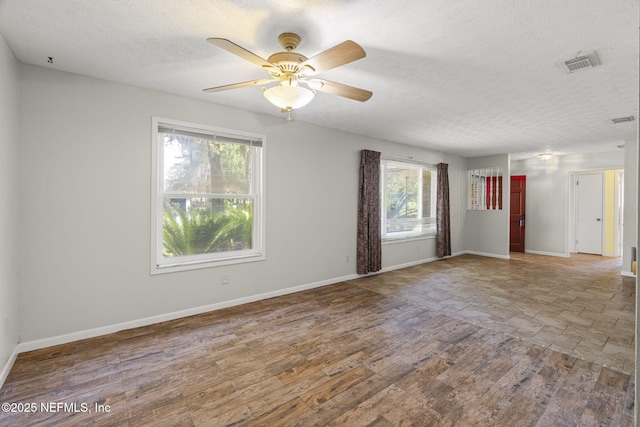 136 Hollywood Forest Dr, Fleming Island, FL 32003 - empty room featuring a textured ceiling, a ceiling fan, and wood finished floors