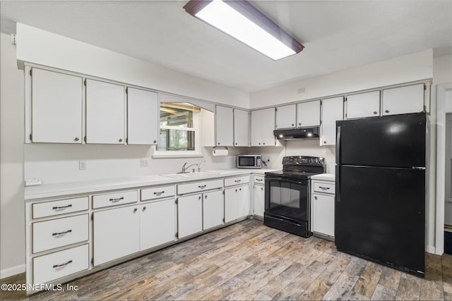 136 Hollywood Forest Dr, Fleming Island, FL 32003 - kitchen with black appliances, light countertops, light wood finished floors, and under cabinet range hood