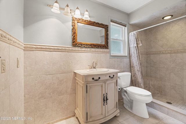 136 Hollywood Forest Dr, Fleming Island, FL 32003 - bathroom featuring vanity, tiled shower, tile patterned flooring, tile walls, and a wainscoted wall