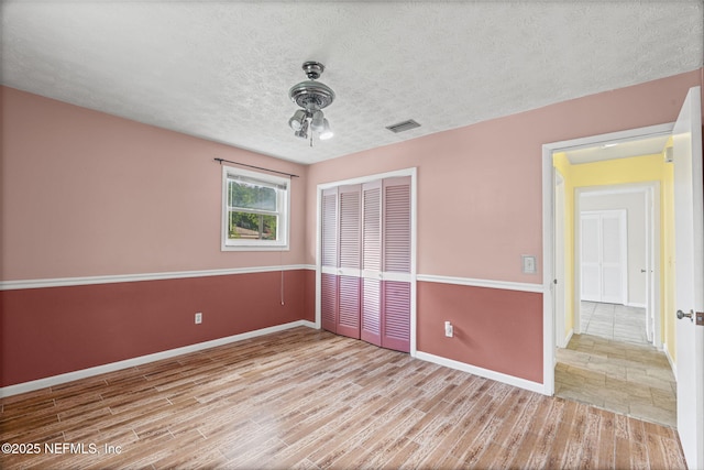 136 Hollywood Forest Dr, Fleming Island, FL 32003 - unfurnished bedroom with a closet, wood finished floors, and a textured ceiling