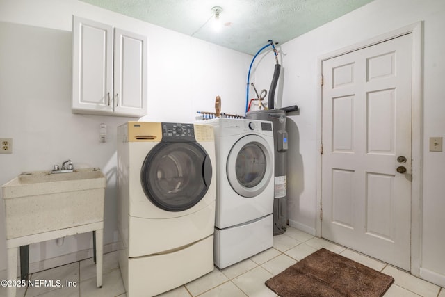 136 Hollywood Forest Dr, Fleming Island, FL 32003 - washroom featuring cabinet space, washer and dryer, light tile patterned flooring, and water heater