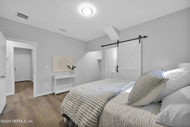 405 W 19th St, Jacksonville, FL 32206 - bedroom with a barn door, a textured ceiling, and wood finished floors
