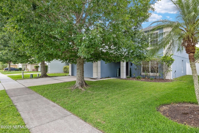 15316 Perdido Dr, Orlando, FL 32828 - view of property hidden behind natural elements featuring driveway, a front lawn, stucco siding, and a garage