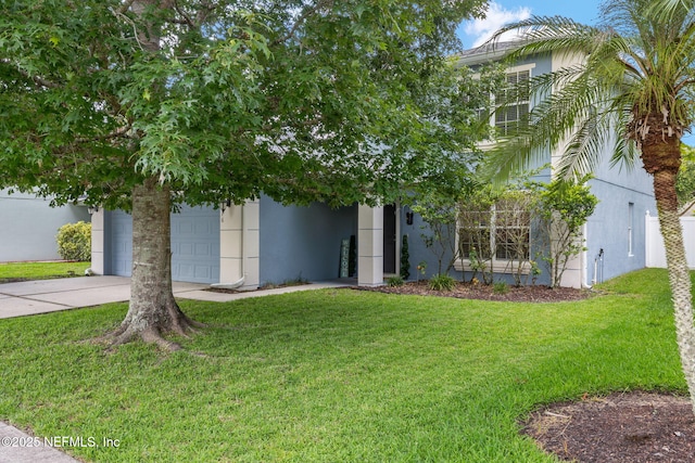 15316 Perdido Dr, Orlando, FL 32828 - obstructed view of property with stucco siding, concrete driveway, a front lawn, and an attached garage