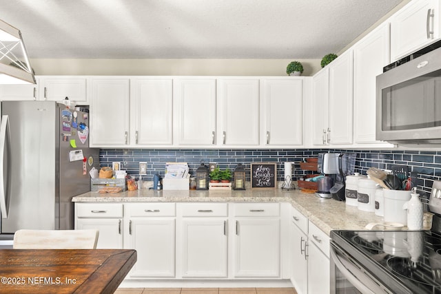 15316 Perdido Dr, Orlando, FL 32828 - kitchen featuring stainless steel appliances, white cabinetry, backsplash, and light tile patterned floors