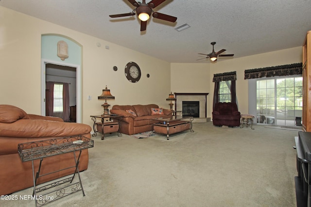 54002 Evergreen Trl, Callahan, FL 32011 - living room featuring a ceiling fan, carpet flooring, a glass covered fireplace, and a textured ceiling