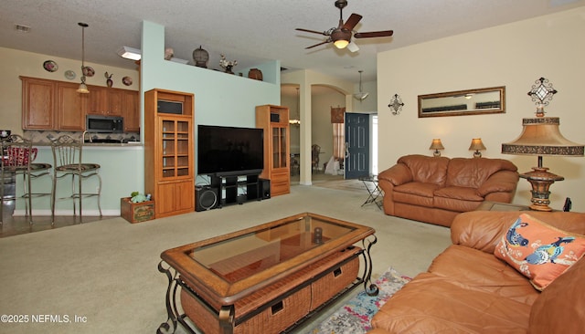 54002 Evergreen Trl, Callahan, FL 32011 - carpeted living room featuring a ceiling fan, a textured ceiling, and arched walkways