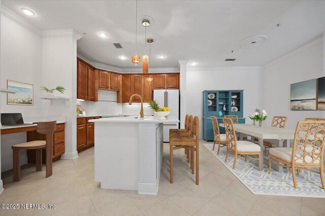 4300 S Beach Pkwy Unit 1206, Jacksonville Beach, FL 32250 - kitchen with ornamental molding, light countertops, freestanding refrigerator, backsplash, and hanging light fixtures