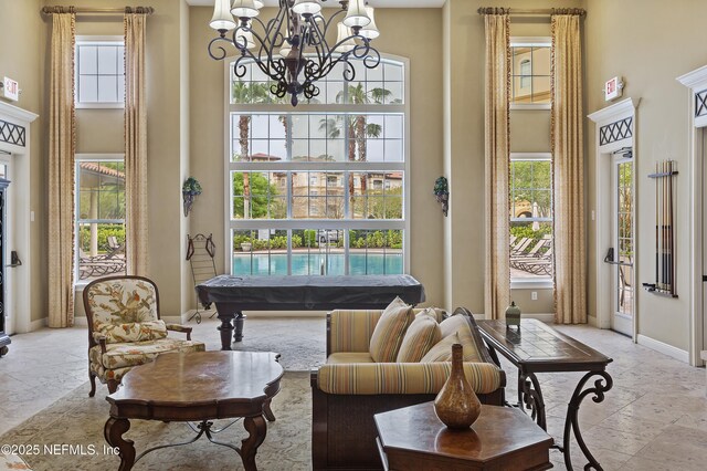 4300 S Beach Pkwy Unit 1206, Jacksonville Beach, FL 32250 - living room with a towering ceiling, stone tile floors, and a chandelier