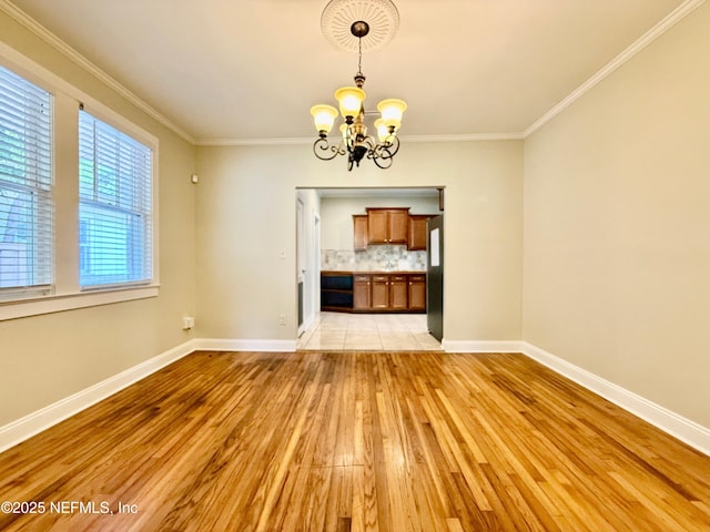 4518 Astral St, Jacksonville, FL 32205 - unfurnished dining area with light wood-style floors, a chandelier, and crown molding