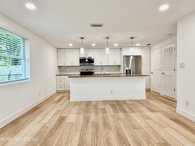 4518 Astral St, Jacksonville, FL 32205 - kitchen featuring appliances with stainless steel finishes, light wood finished floors, decorative backsplash, recessed lighting, and white cabinetry
