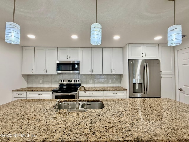 4518 Astral St, Jacksonville, FL 32205 - kitchen featuring appliances with stainless steel finishes, white cabinetry, backsplash, recessed lighting, and light stone countertops