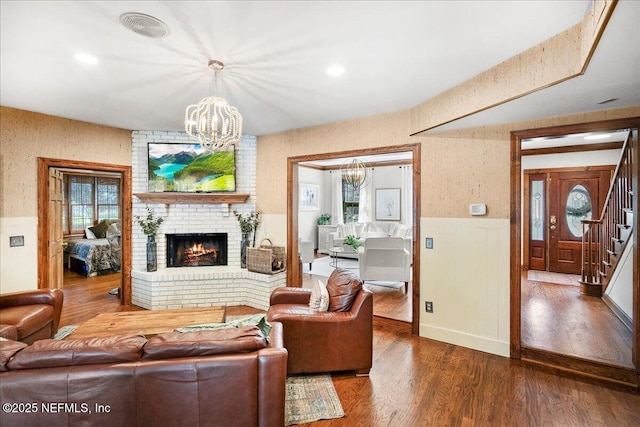 2748 Scott Mill Ter, Jacksonville, FL 32257 - living room with a chandelier, wainscoting, wood finished floors, stairs, and a brick fireplace