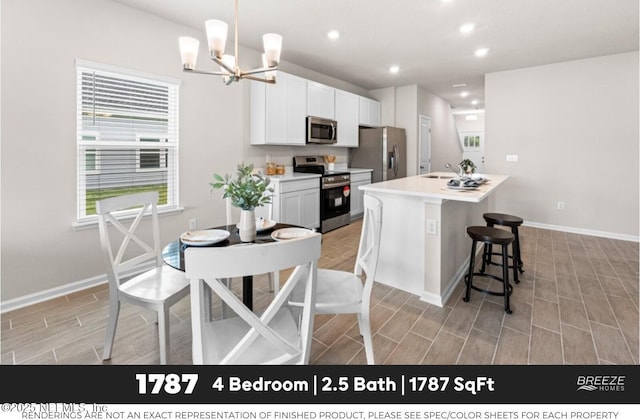 3559 Mildred Way, Jacksonville, FL 32254 - kitchen with stainless steel appliances, wood finish floors, a center island with sink, a chandelier, and light countertops