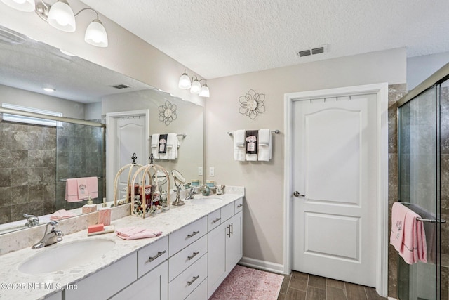 44 Spotted Owl Ln, Saint Augustine, FL 32095 - full bathroom featuring double vanity, a shower stall, a textured ceiling, and wood finish floors