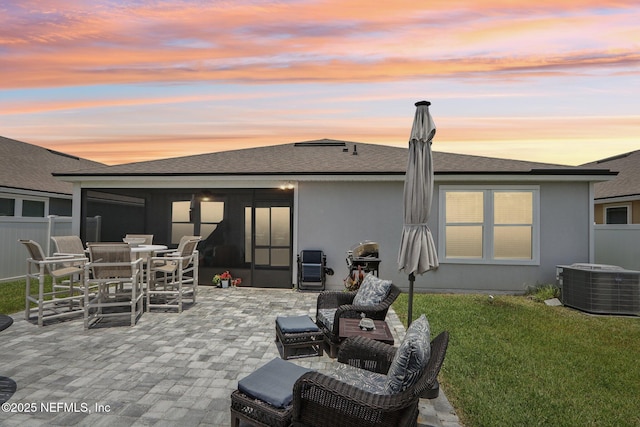 44 Spotted Owl Ln, Saint Augustine, FL 32095 - back of house at dusk featuring a patio, stucco siding, roof with shingles, and outdoor dining space