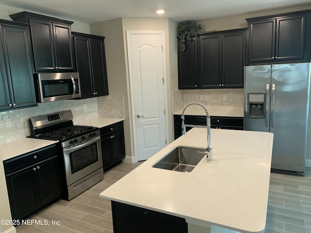 488 Broomsedge Cir, Saint Augustine, FL 32095 - kitchen with stainless steel appliances, dark cabinets, wood tiled floors, recessed lighting, and tasteful backsplash