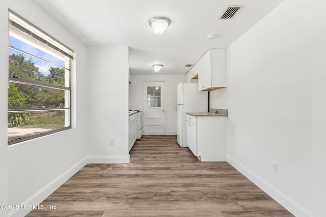9043 8th Ave, Jacksonville, FL 32208 - kitchen featuring white cabinetry, freestanding refrigerator, and light wood-style floors