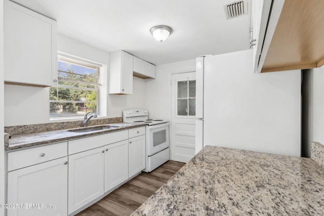 9043 8th Ave, Jacksonville, FL 32208 - kitchen with white appliances, wood finished floors, light stone countertops, and white cabinetry