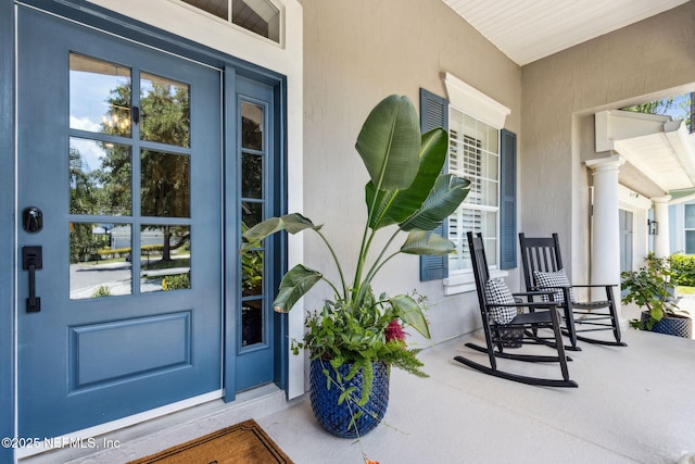 95006 Buckeye Ct, Fernandina Beach, FL 32034 - doorway to property with covered porch and stucco siding