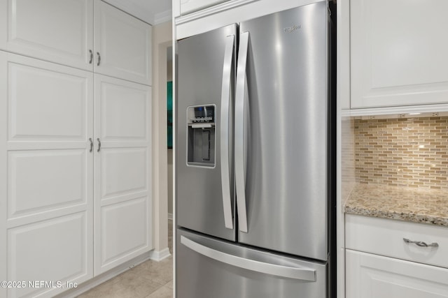 106 Poseidon Ln, Ponte Vedra Beach, FL 32082 - kitchen with stainless steel fridge, backsplash, white cabinets, light stone counters, and light tile patterned flooring