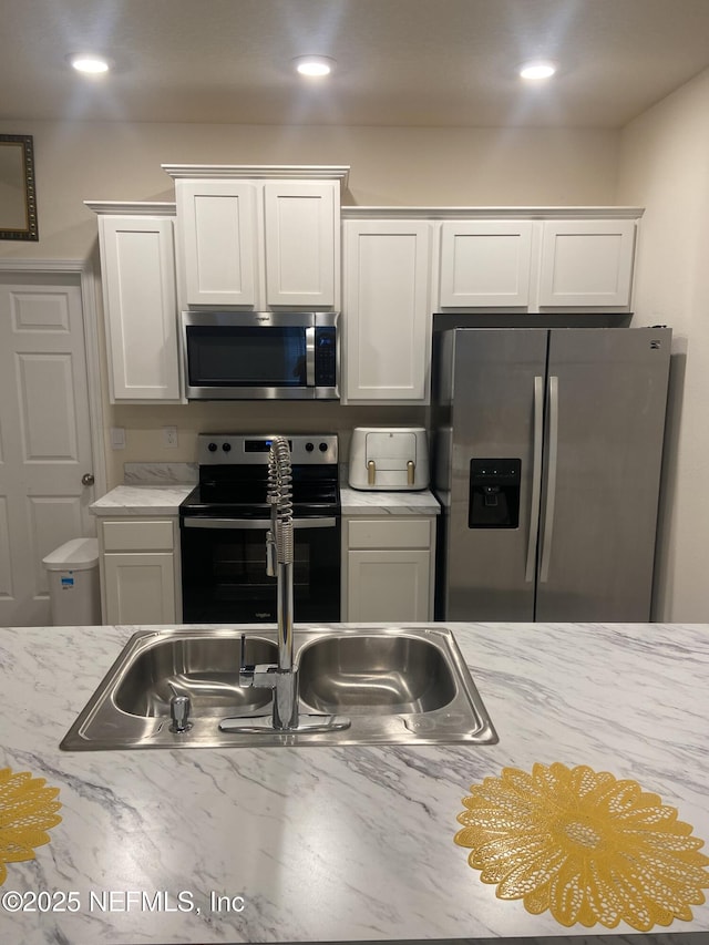 86568 Shortline Cir, Yulee, FL 32097 - kitchen with appliances with stainless steel finishes, white cabinetry, and recessed lighting