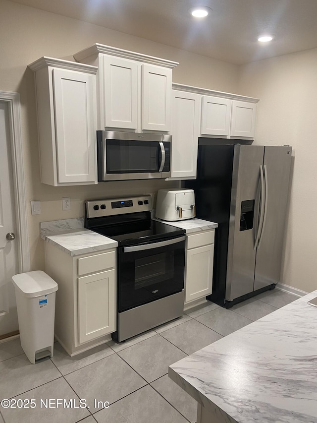 86568 Shortline Cir, Yulee, FL 32097 - kitchen featuring appliances with stainless steel finishes, light countertops, white cabinets, light tile patterned floors, and recessed lighting