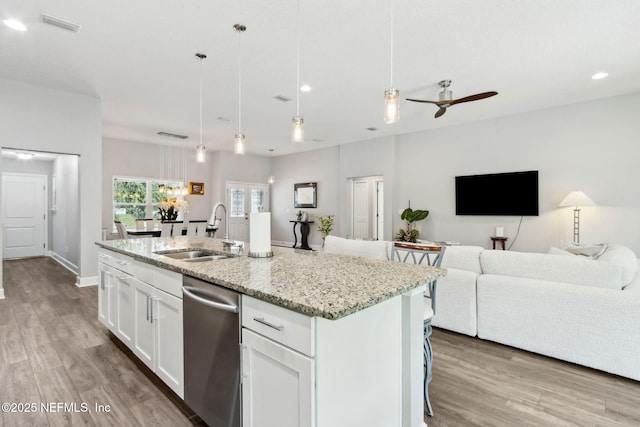 75652 Edwards Rd, Yulee, FL 32097 - kitchen featuring stainless steel dishwasher, open floor plan, light stone counters, light wood finished floors, and ceiling fan