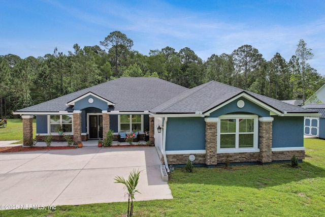75652 Edwards Rd, Yulee, FL 32097 - view of front of house featuring stone siding, a front yard, stucco siding, and a shingled roof