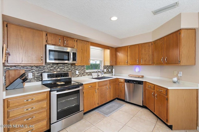 101 Duck Bill Cv, Ponte Vedra Beach, FL 32082 - kitchen with appliances with stainless steel finishes, a textured ceiling, brown cabinets, tasteful backsplash, and light countertops