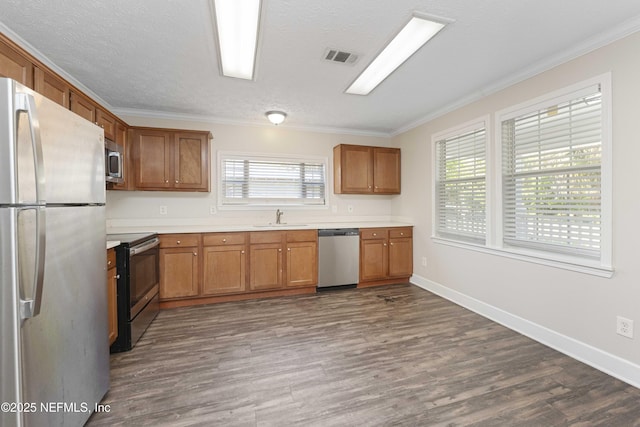 103 Chapin St, Saint Augustine, FL 32084 - kitchen with appliances with stainless steel finishes, ornamental molding, dark wood-style floors, plenty of natural light, and light countertops