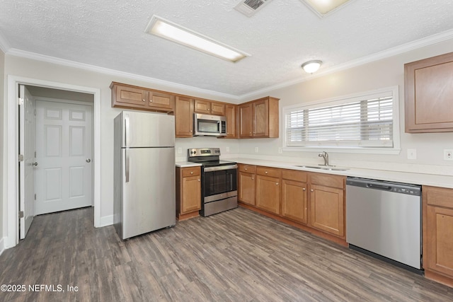 103 Chapin St, Saint Augustine, FL 32084 - kitchen with stainless steel appliances, a textured ceiling, dark wood-style floors, crown molding, and light countertops